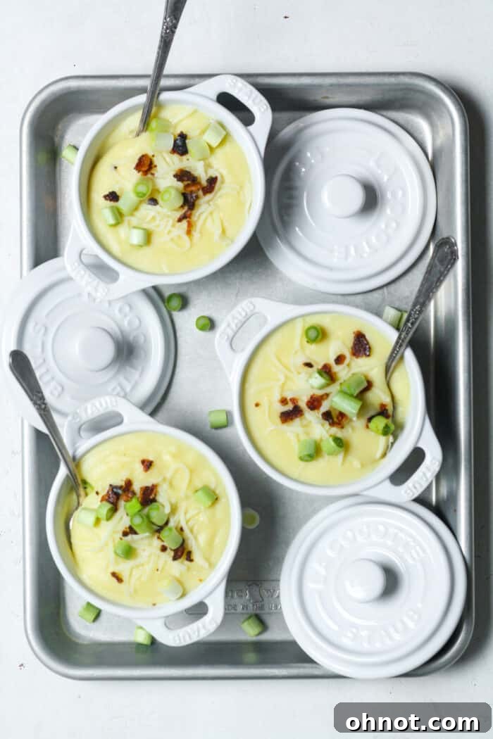 Creamy potato soup in a rustic bowl, topped generously with crispy bacon and fresh green onions, ready to be eaten.