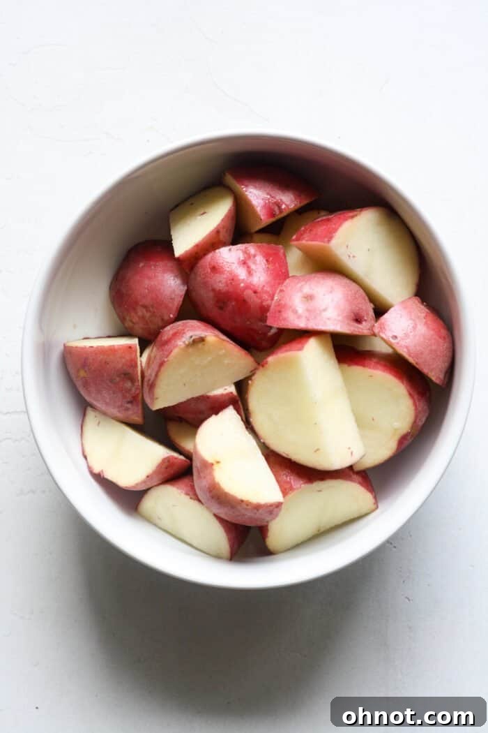 Chopped baby red potatoes on a cutting board