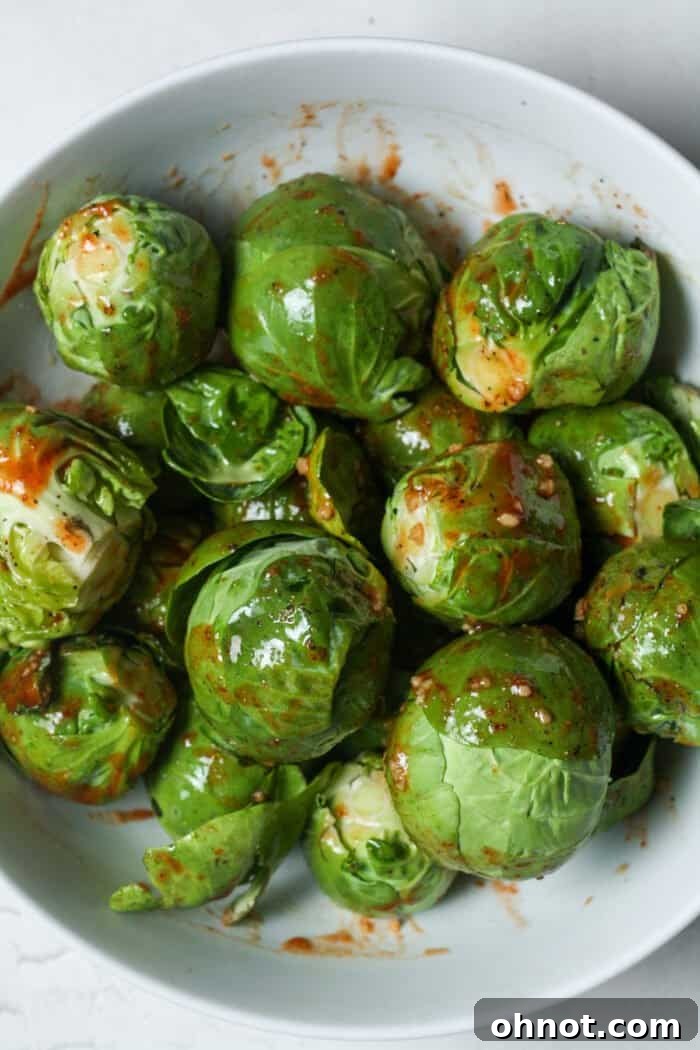 Vegetables with sauce on them, ready to be roasted