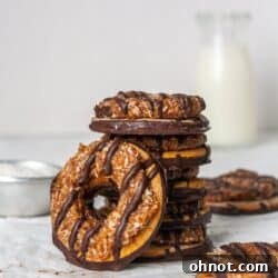 A stack of Samoa cookies with a glass of milk.