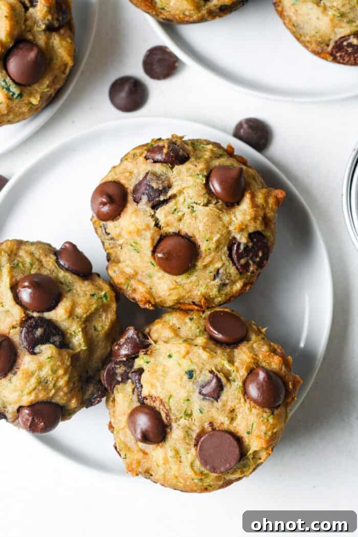 Beautifully baked vegan and gluten-free chocolate chip zucchini muffins on a cooling rack, showcasing their golden tops and delicious texture.