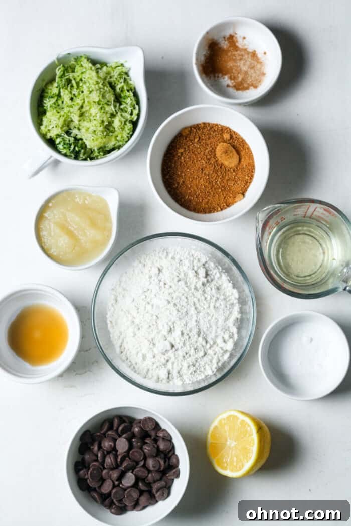 Bowls of fresh ingredients for vegan zucchini muffins, including grated zucchini, flour, and chocolate chips, ready for mixing.
