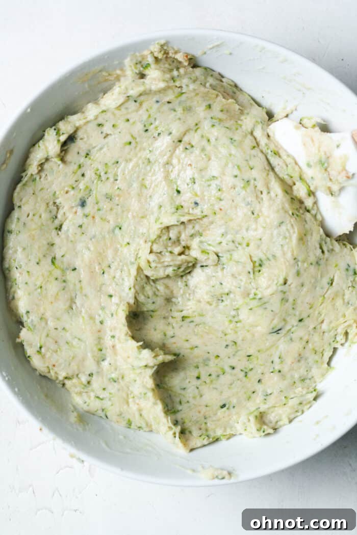 Thick, well-combined zucchini muffin batter in a mixing bowl, showcasing its consistency.