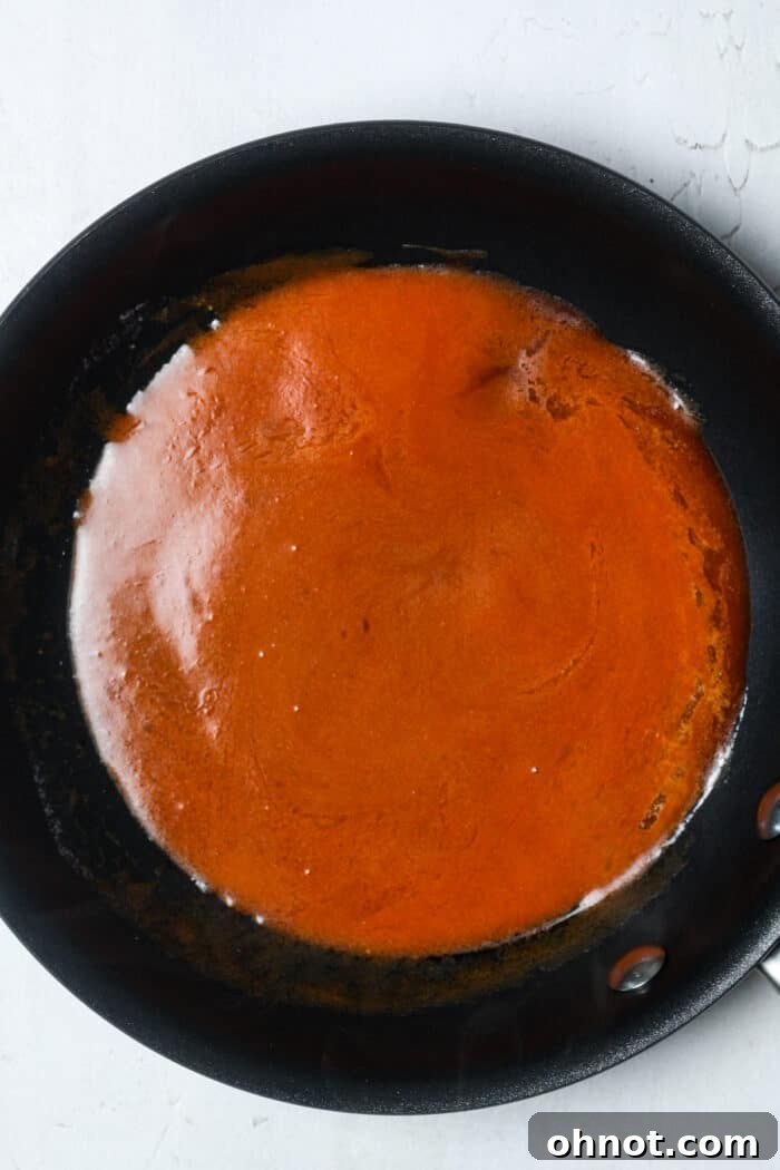 Smooth and buttery hot sauce mixture in a pan, ready for coating the chicken.