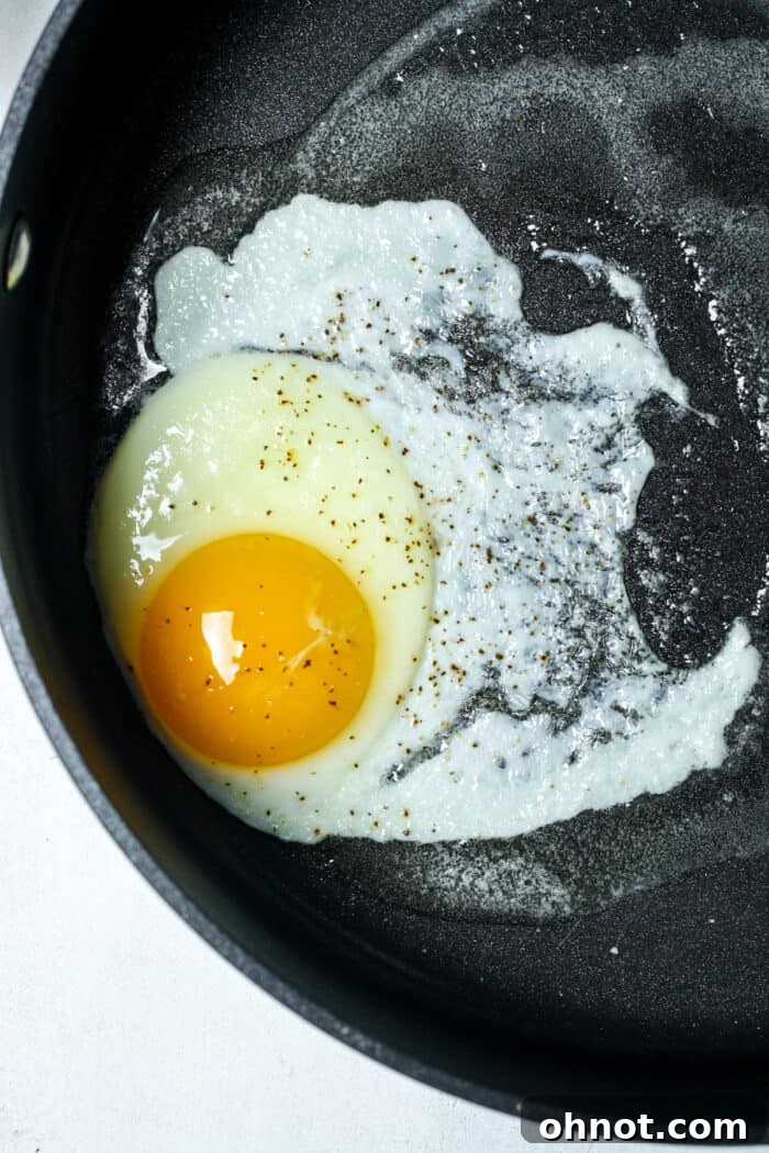 Single fried egg cooking in butter in a pan