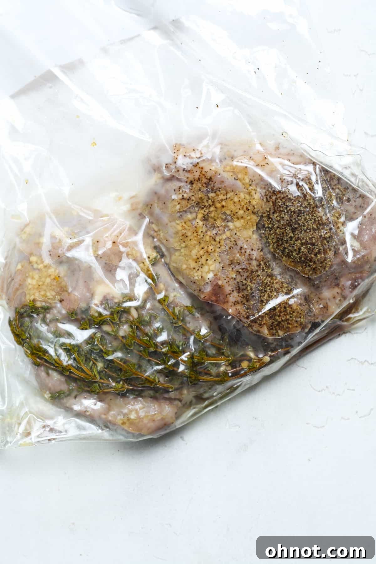 Succulent lamb chops, perfectly cooked sous vide, are extracted from the bag, showcasing their even pink color and readiness for searing.