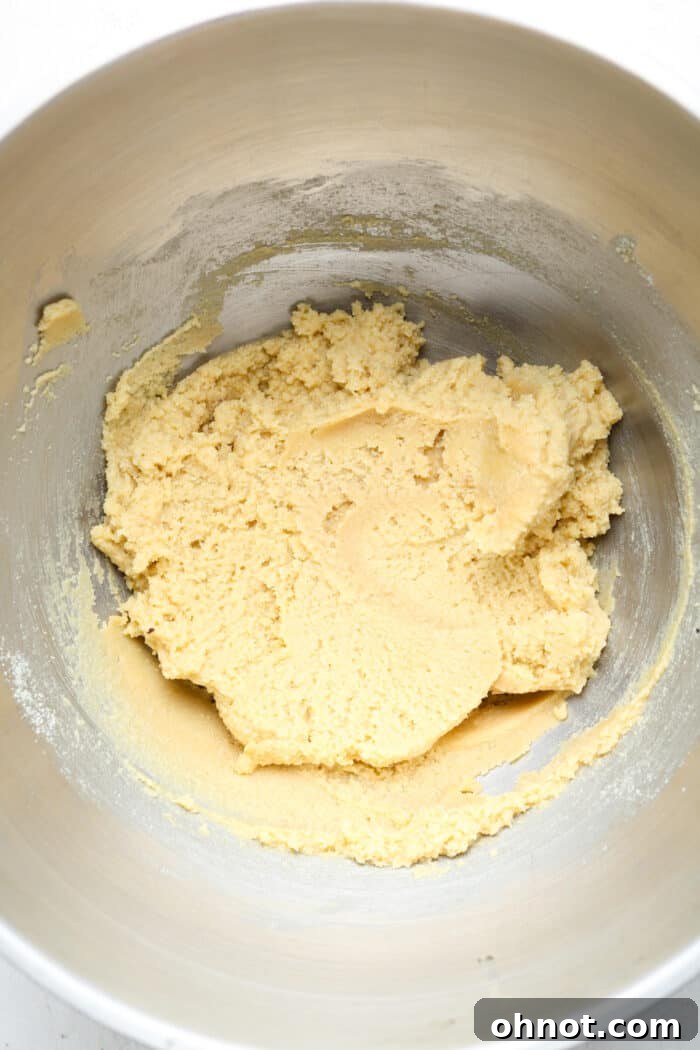 Light-colored cookie dough in a large mixing bowl, ready for chocolate chips