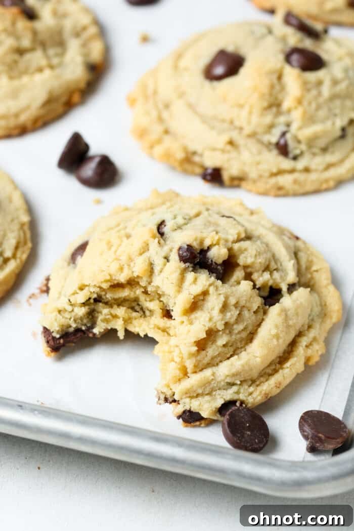 A batch of freshly baked almond flour chocolate chip cookies, still warm on the baking pan