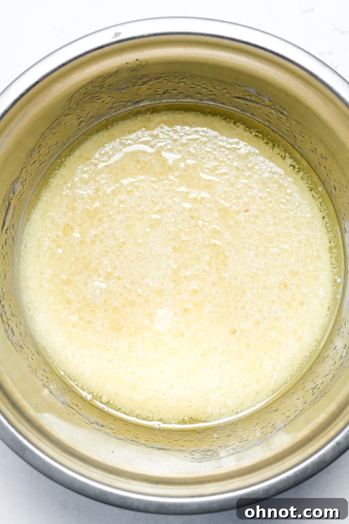 A large mixing bowl containing the runny wet batter ingredients for the vegan coffee cake, stirred and ready for dry ingredients.