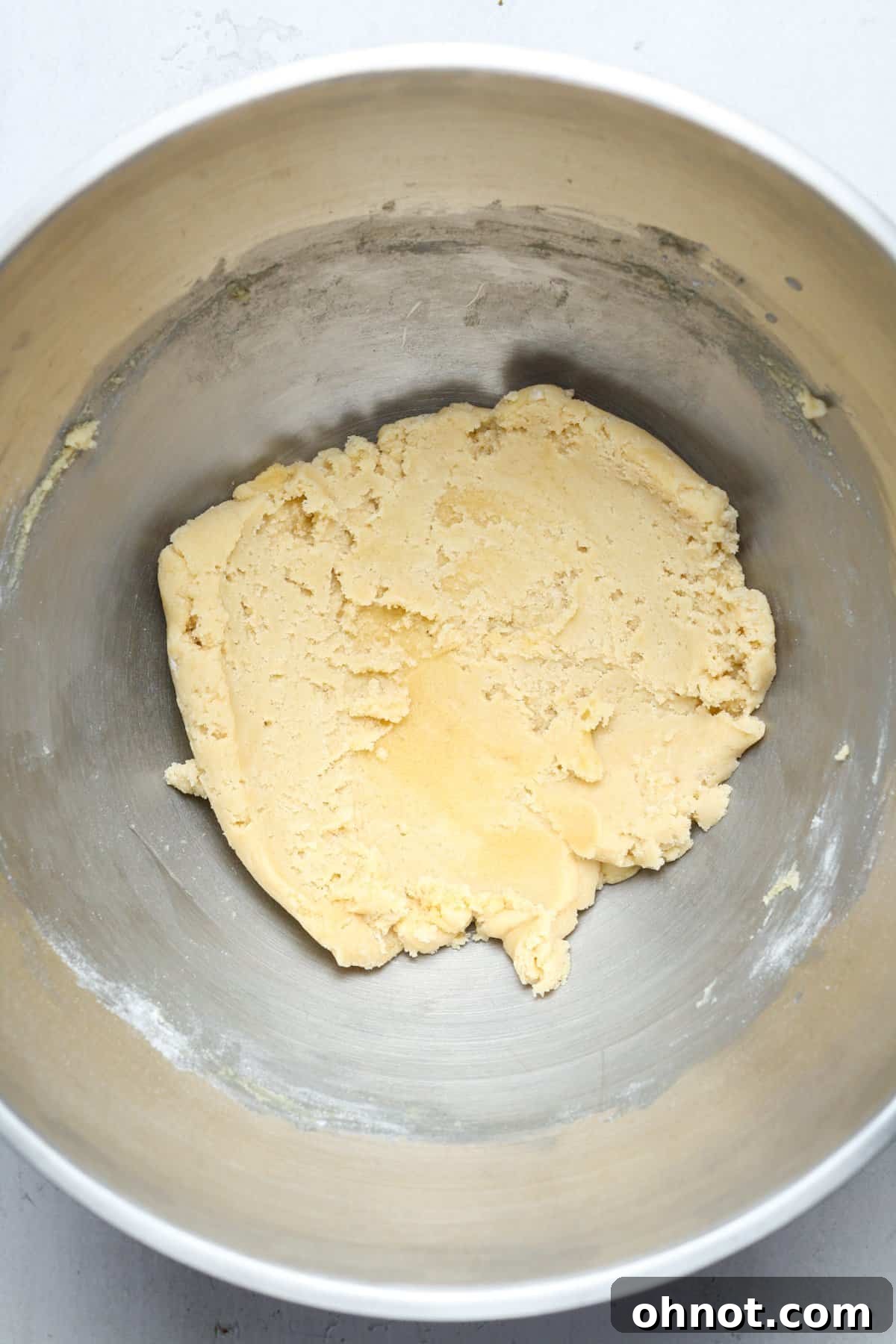Smooth, un-chipped cookie dough in a mixing bowl, before the chocolate chips are folded in.