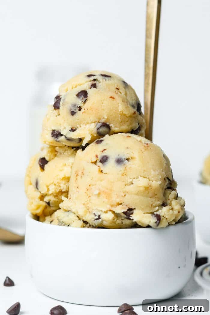A generous serving of gluten-free cookie dough in a white bowl, highlighting its rich texture and chocolate chips.