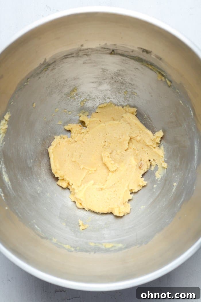 A bowl filled with perfectly creamed butter and sugars, showcasing a light, fluffy, and lump-free texture ready for the next steps