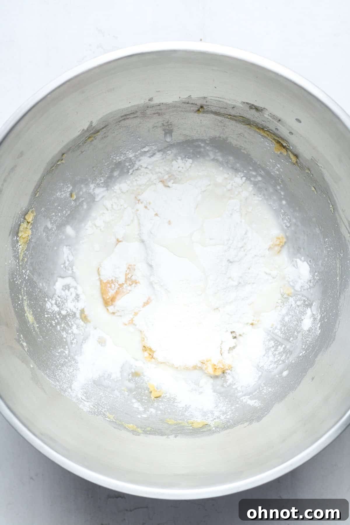 The initial stage of mixing, with dry ingredients added to the wet mixture in a mixing bowl, before full incorporation