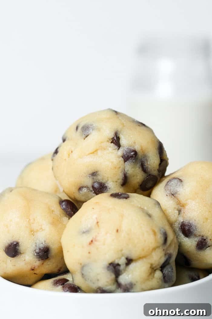 A collection of perfectly formed, bite-sized chocolate chip cookie dough balls, showcasing their ready-to-eat appeal