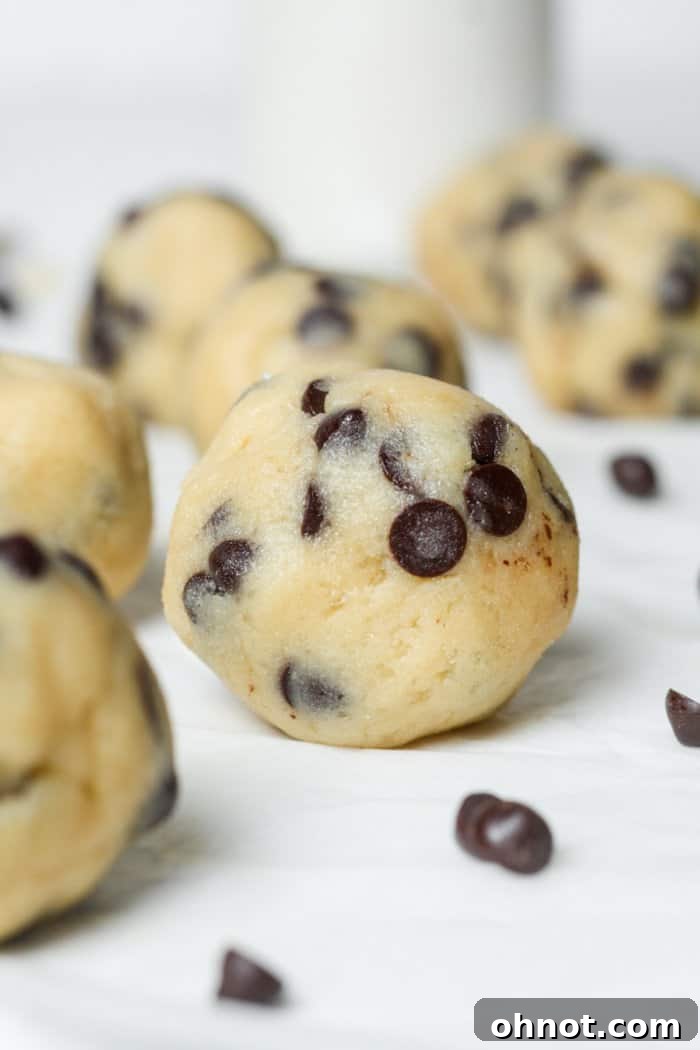 A close-up of rolled cookie dough bites, showcasing their smooth texture and even distribution of mini chocolate chips