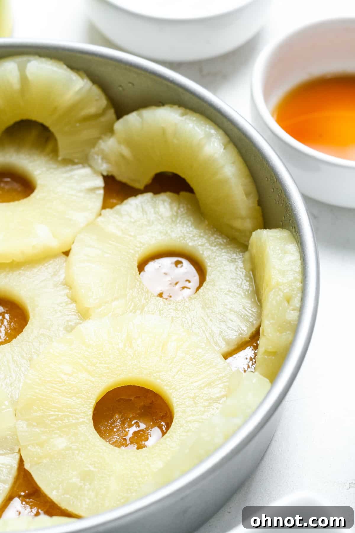 Pineapple rings filling the cake pan, with halves along the edges.