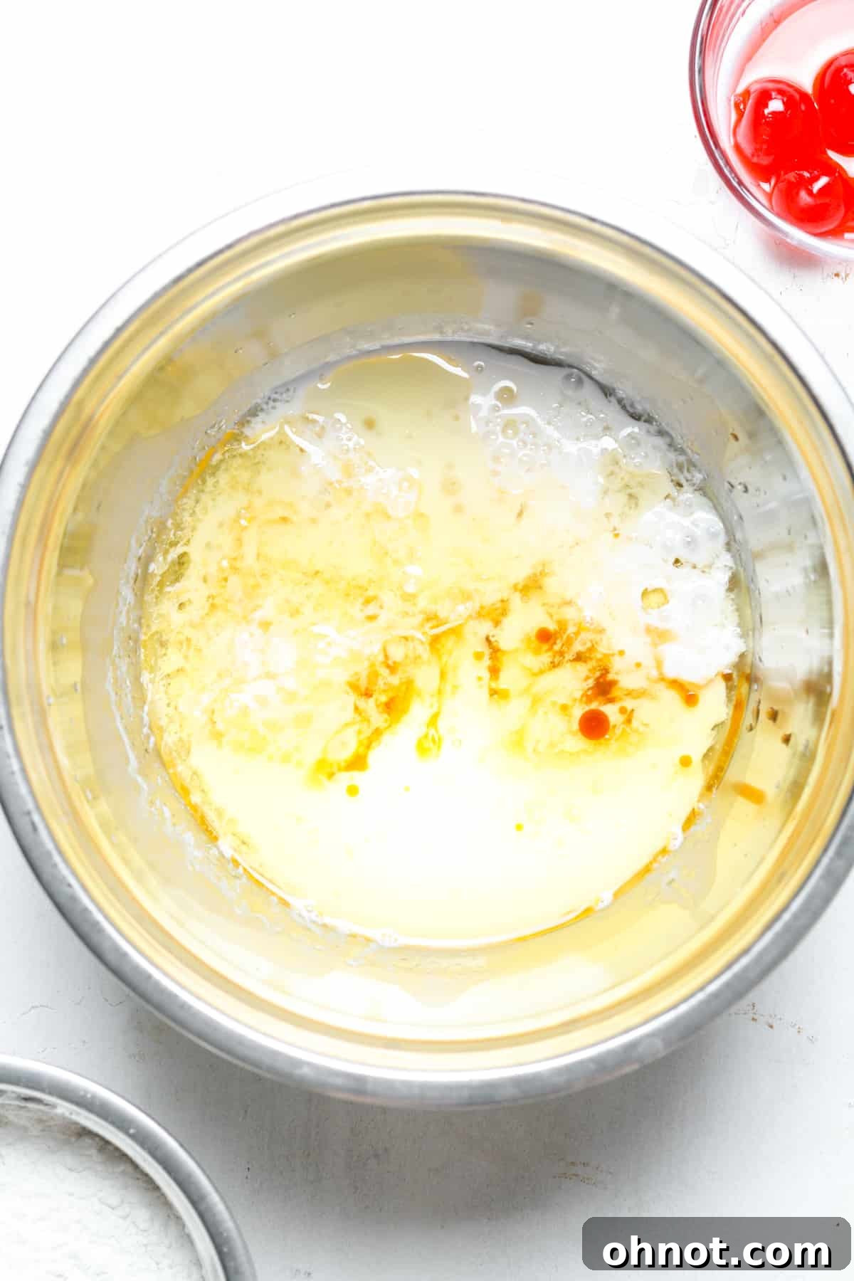 Oil and vinegar being added to a mixing bowl.