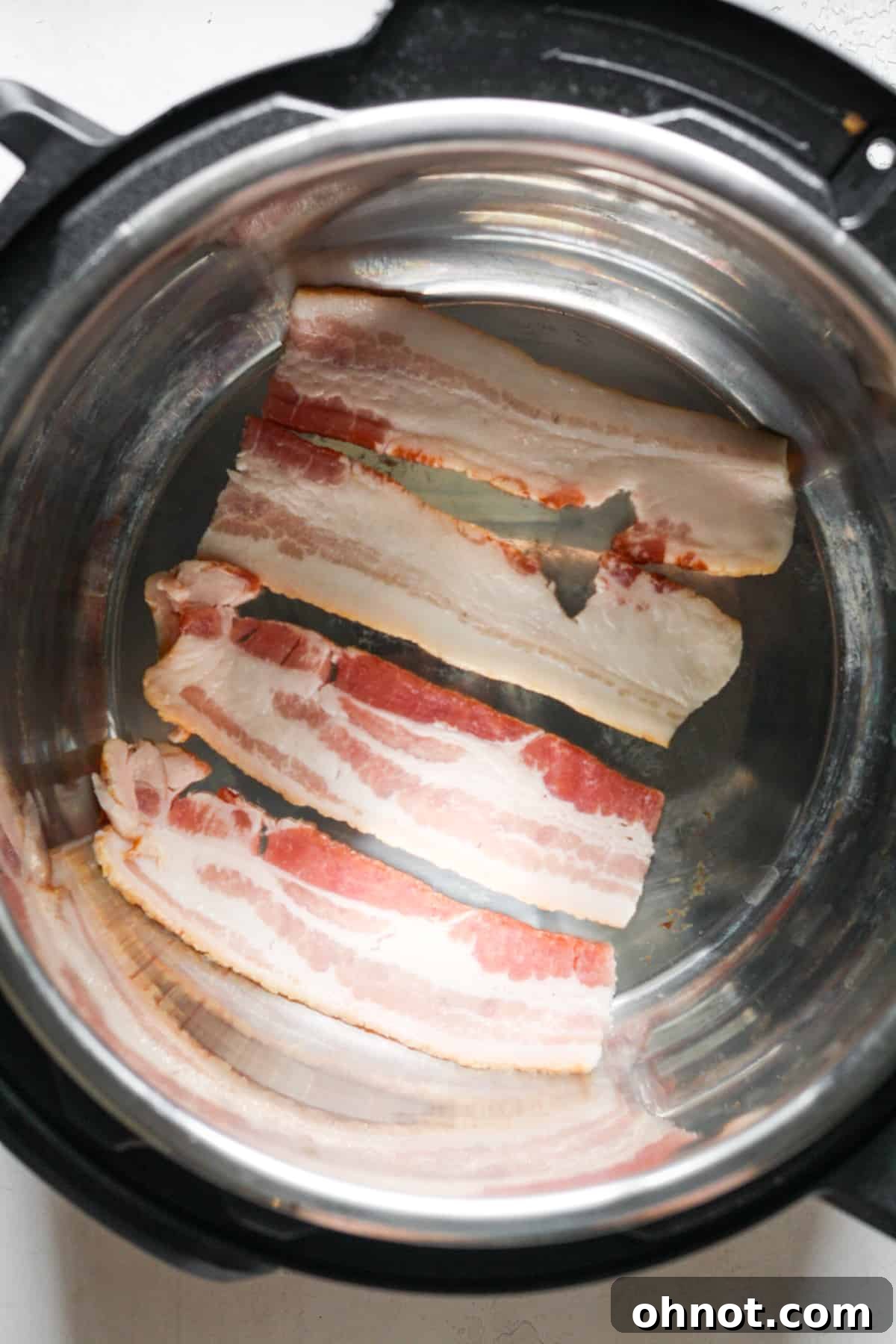 Raw bacon strips cooking in the Instant Pot