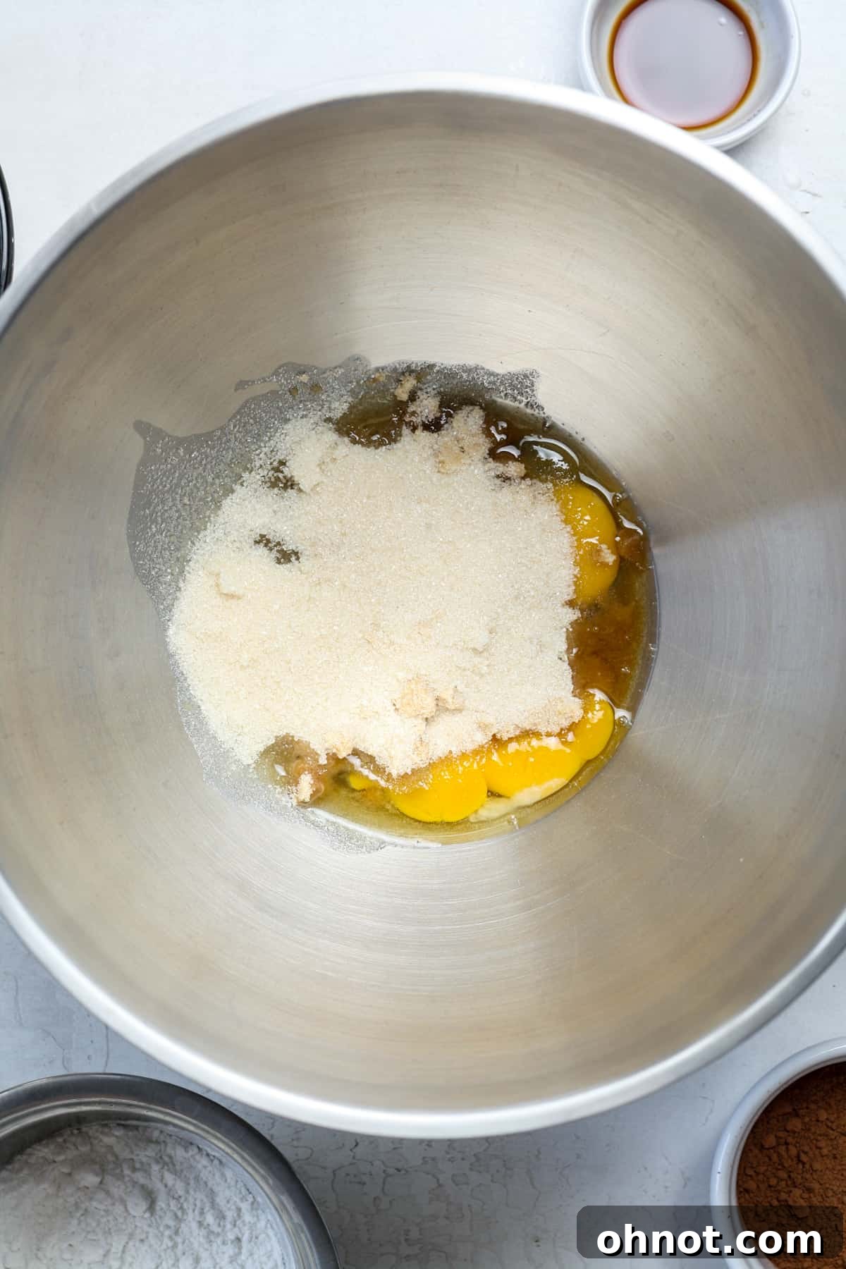 Eggs, light brown sugar, and granulated sugar in a mixing bowl before beating