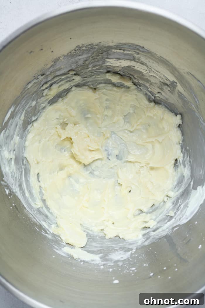 Smooth and creamy vanilla cheesecake filling in a stand mixer bowl.