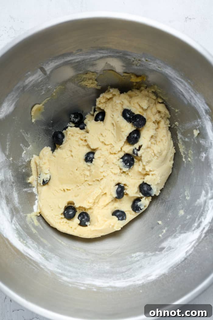 Blueberry cookie dough in a bowl with fresh blueberries gently folded in.