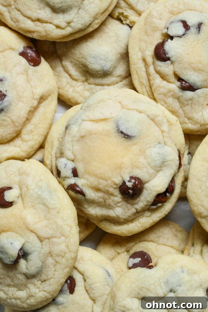 Perfectly baked chocolate chip cheesecake cookies, warm and gooey, highlighting the golden-brown exterior and hints of chocolate.