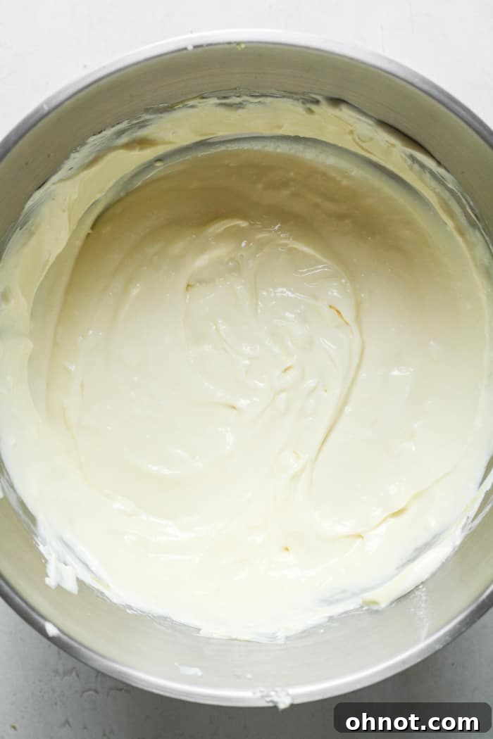 Cheesecake batter in a bowl, with eggs just incorporated, ready for chocolate chips.