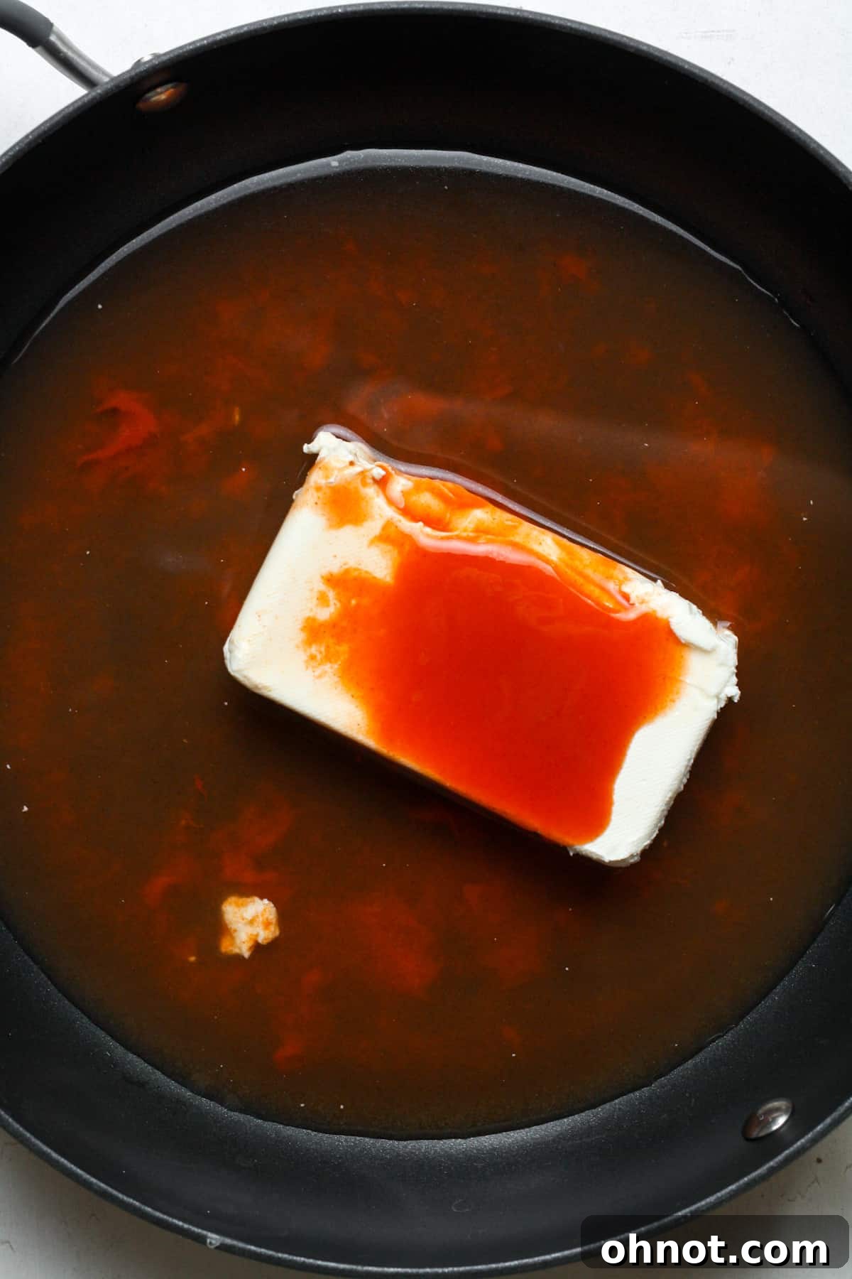 Cream cheese and hot sauce in skillet