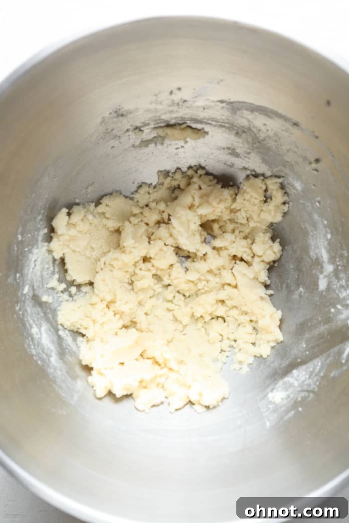 Light-colored dough forming in the bowl after adding dry ingredients.