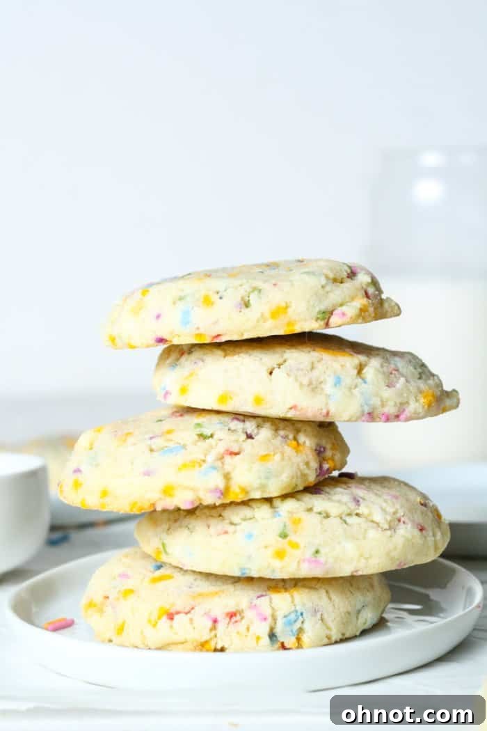 A whimsical and artfully arranged stack of freshly baked sugar cookies with colorful sprinkles.
