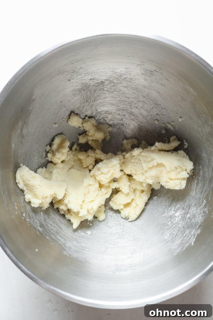 Close-up of a mixing bowl containing white granulated sugar and cold butter, ready to be creamed together.