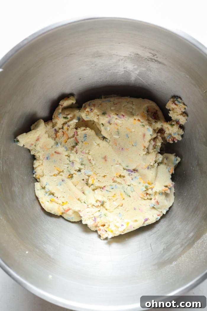 Cookie dough with colorful sprinkles folded in, ready to be scooped and baked.