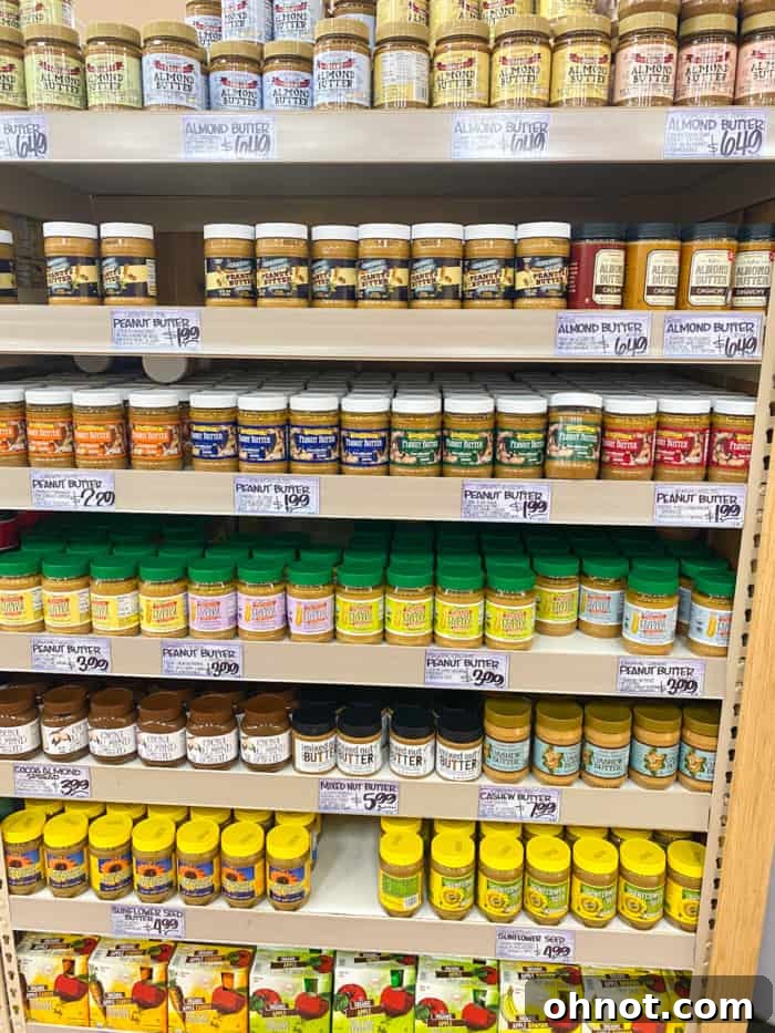 A colorful display of various peanut butter jars at Trader Joe's, highlighting diverse options for spreads.