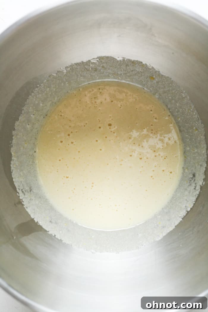 Frothy mixture of beaten eggs and sugar, indicating proper aeration for shiny brownie tops.