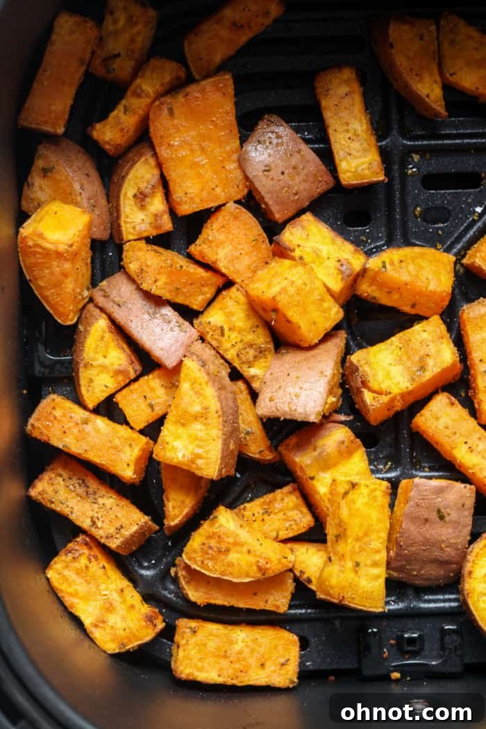 Roasted sweet potato cubes in the air fryer basket after cooking.