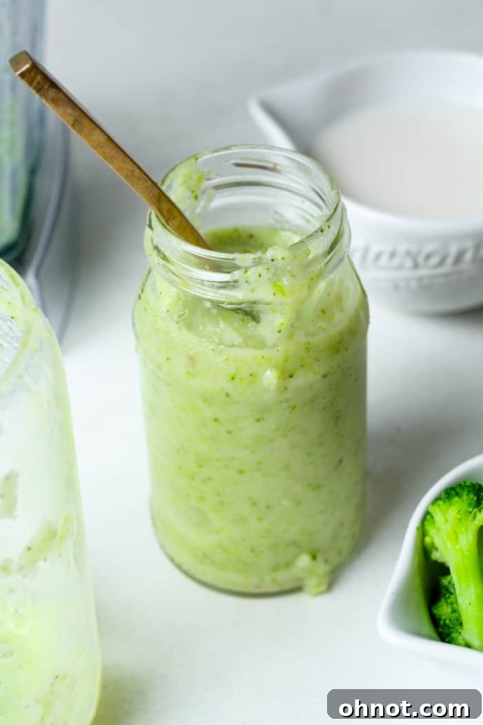 A thick, creamy green smoothie served in a jar, ready to drink.