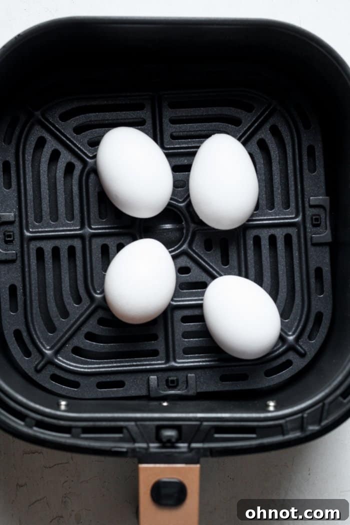 Raw eggs arranged neatly in an air fryer basket.