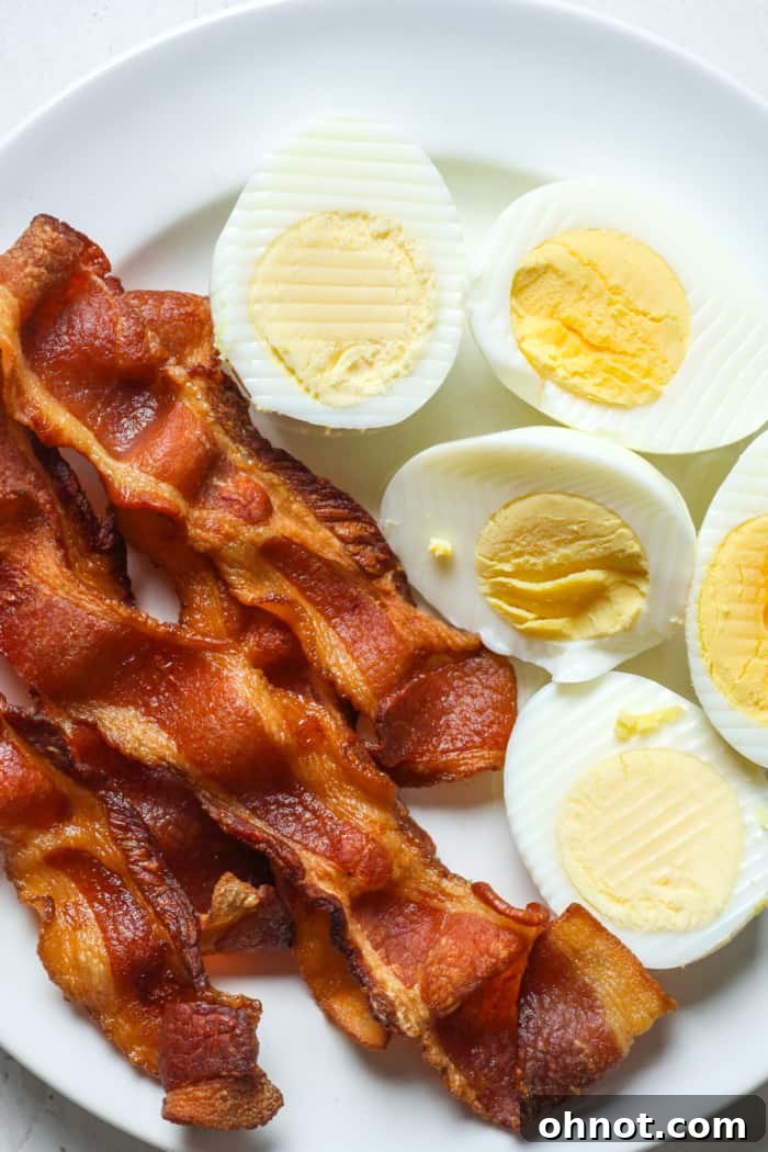 A breakfast plate featuring sliced hard boiled eggs with toast and fresh vegetables.