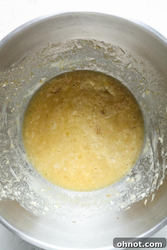 A bowl filled with a smooth, well-combined mixture of wet ingredients for banana muffins.