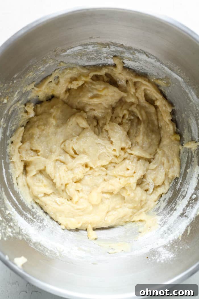 Thick, golden muffin batter in a mixing bowl after combining wet and dry ingredients.