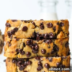 A perfectly baked loaf of golden-brown dairy-free banana bread, sliced to reveal its moist interior, ready to be served.