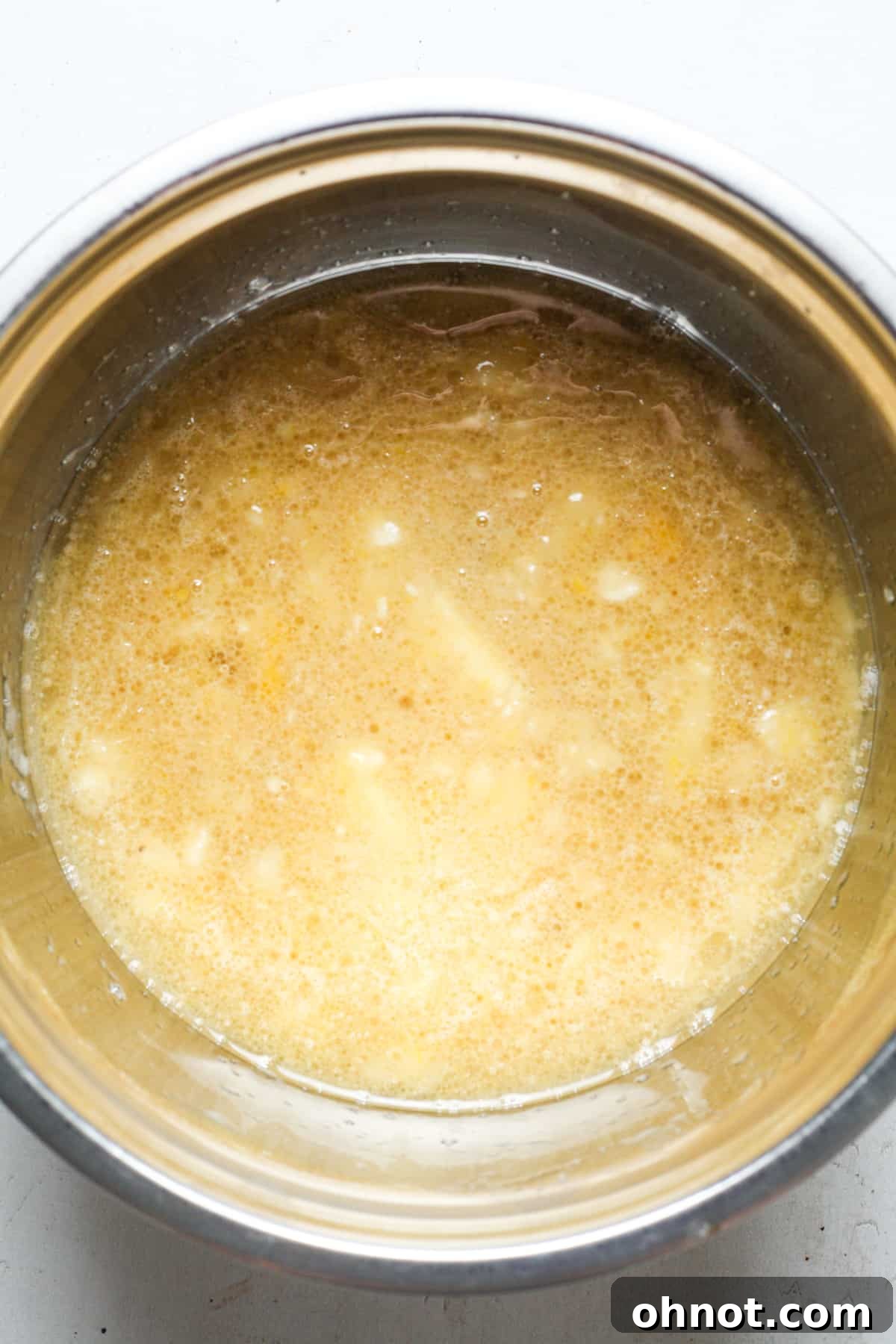 The runny, well-combined banana bread batter, showing all the wet ingredients mixed together.