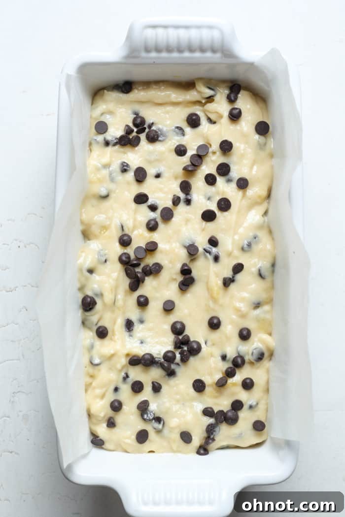 Banana bread batter evenly spread into a loaf pan, ready for baking.