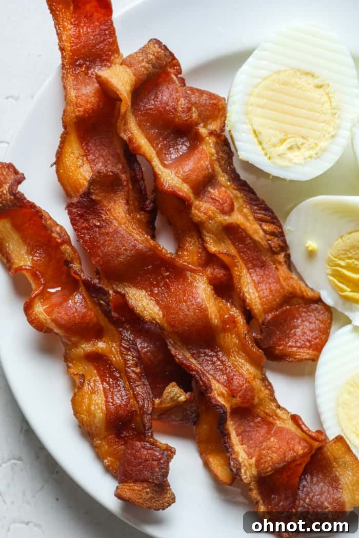 A hearty breakfast plate with crispy air fryer bacon and scrambled eggs.