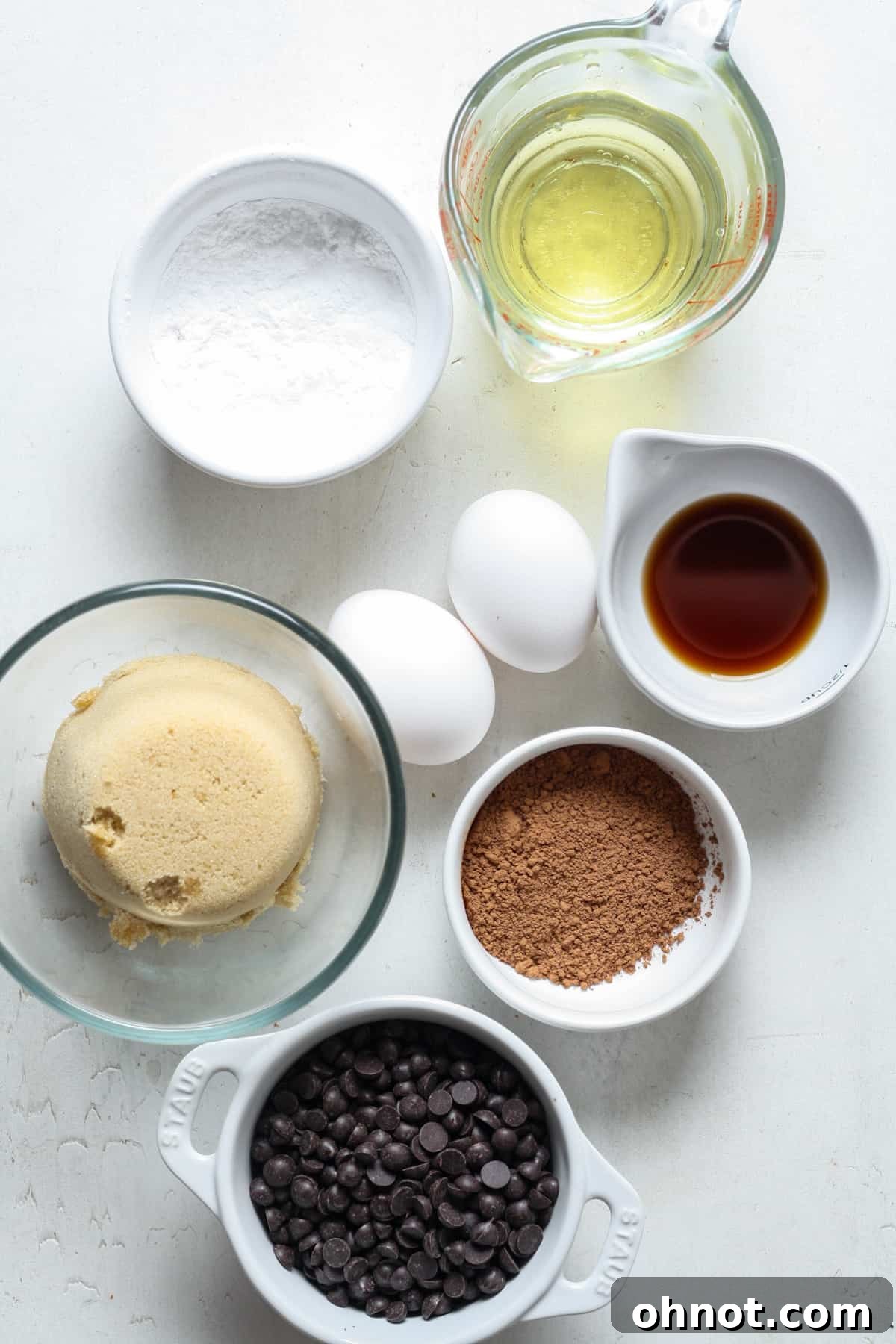 Assorted baking ingredients including dark chocolate chips, flour, and sugars, ready for mixing.