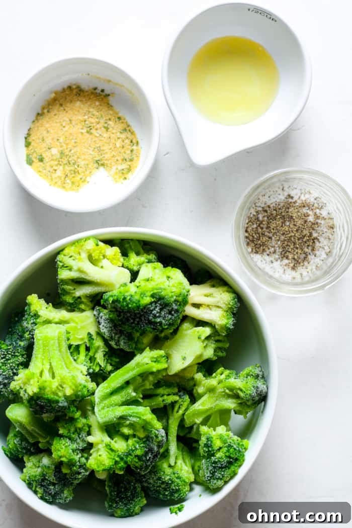 Green broccoli florets tossed with olive oil and seasonings in a bowl, ready for the air fryer.