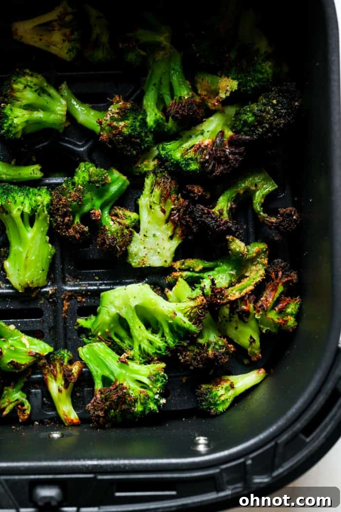 Crispy air-fried broccoli florets after cooking, in the air fryer basket.