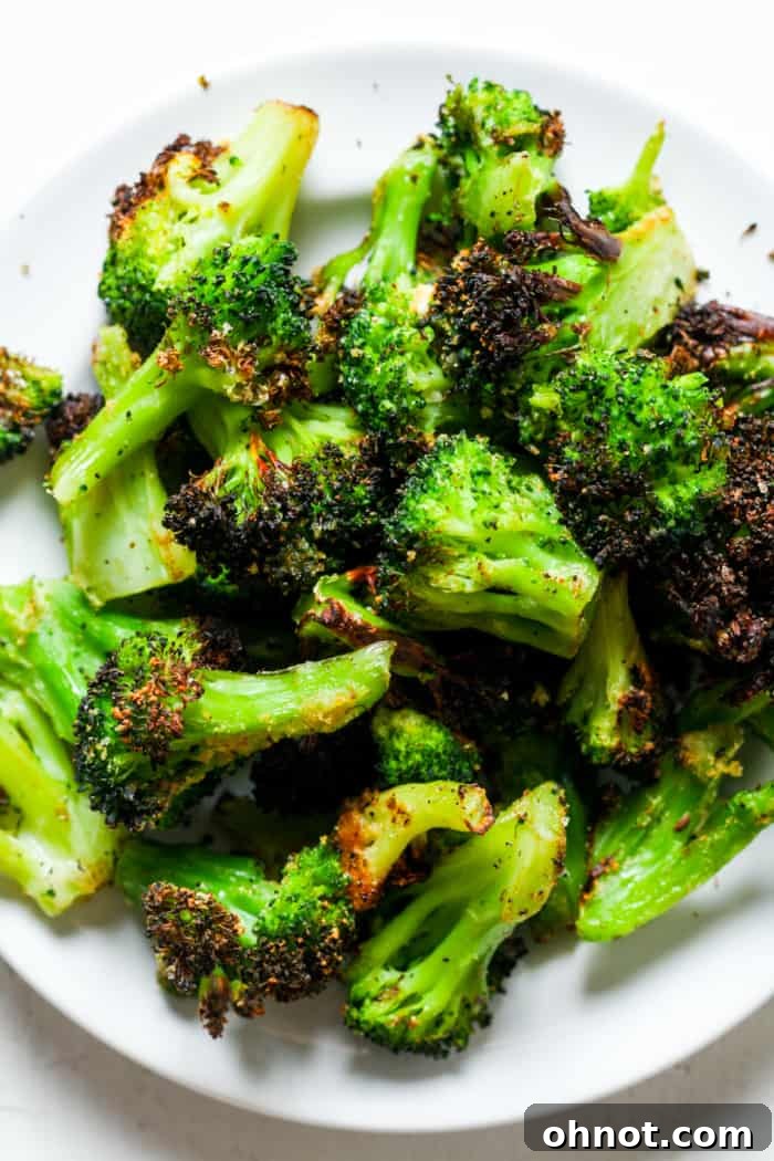 A plate of perfectly cooked, crispy air-fried broccoli florets.
