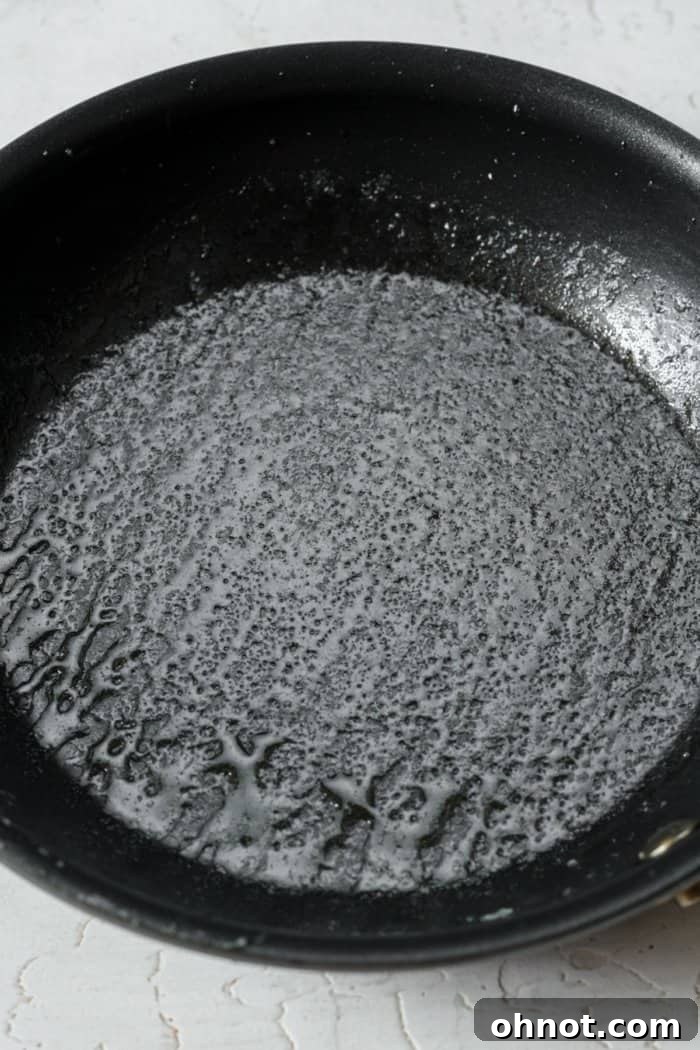 A small, greased mini skillet ready for the cookie dough.