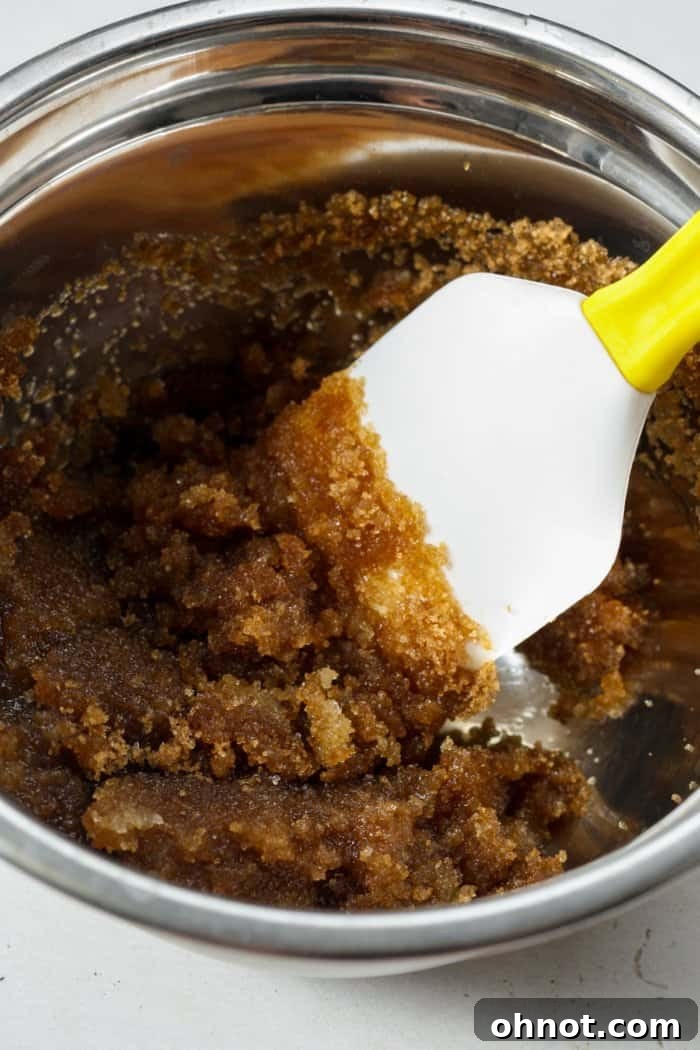 Melted butter combined with brown and granulated sugar in a mixing bowl.